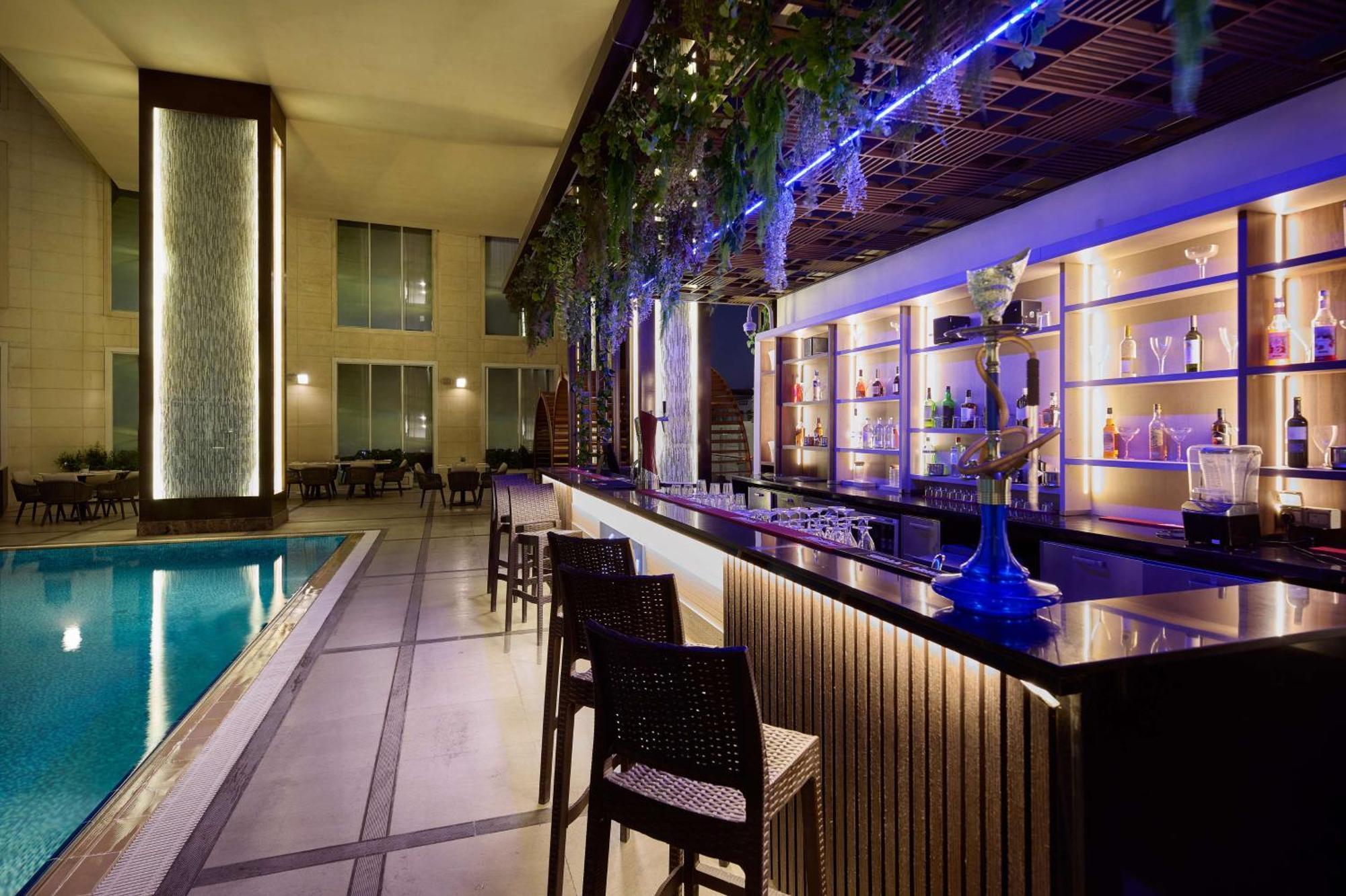 Doubletree By Hilton Doha - Al Sadd Hotel Bagian luar foto The bar at the pool